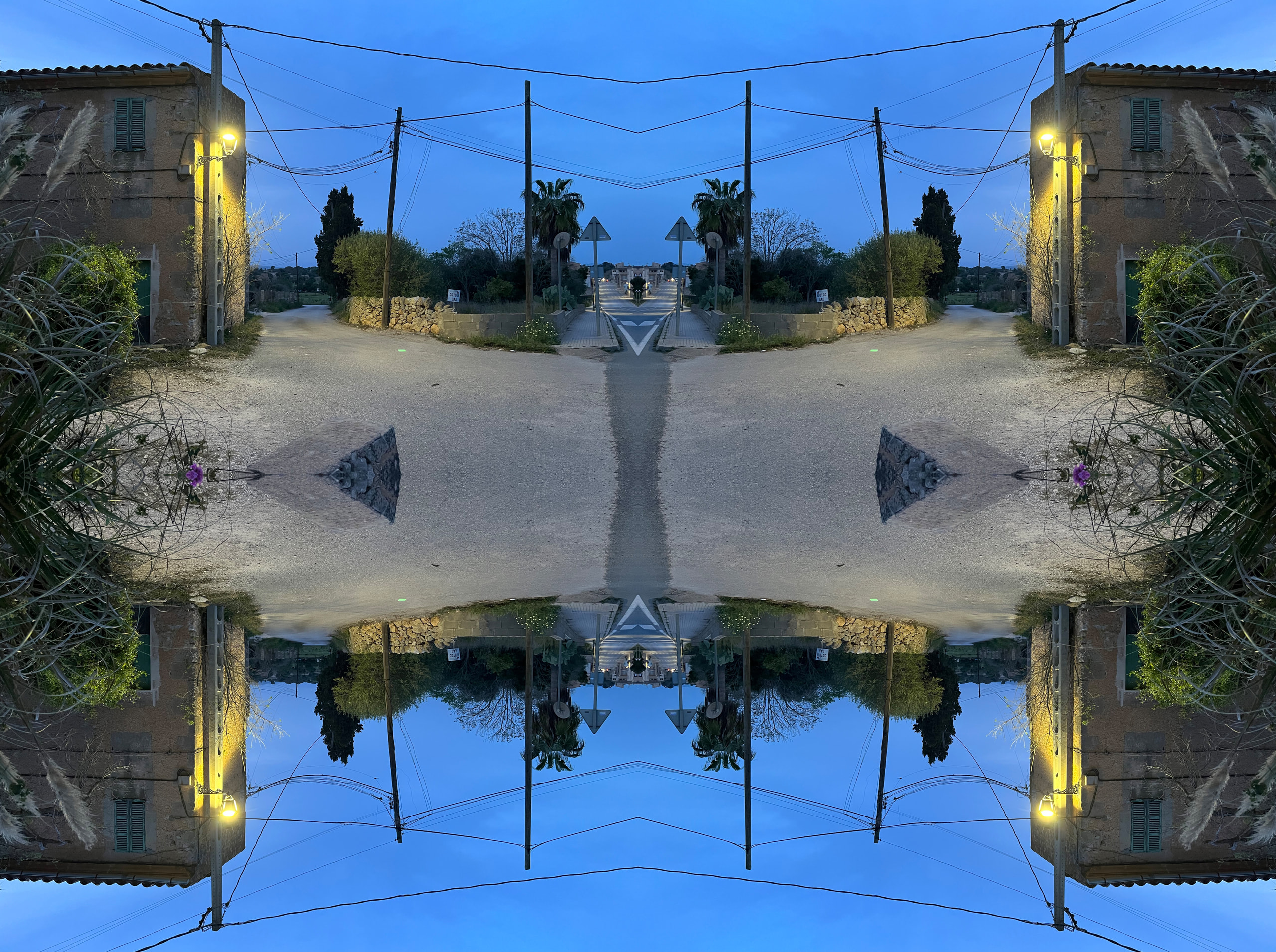 A village street at dusk reflected horizontally and vertically into a symmetrical composition