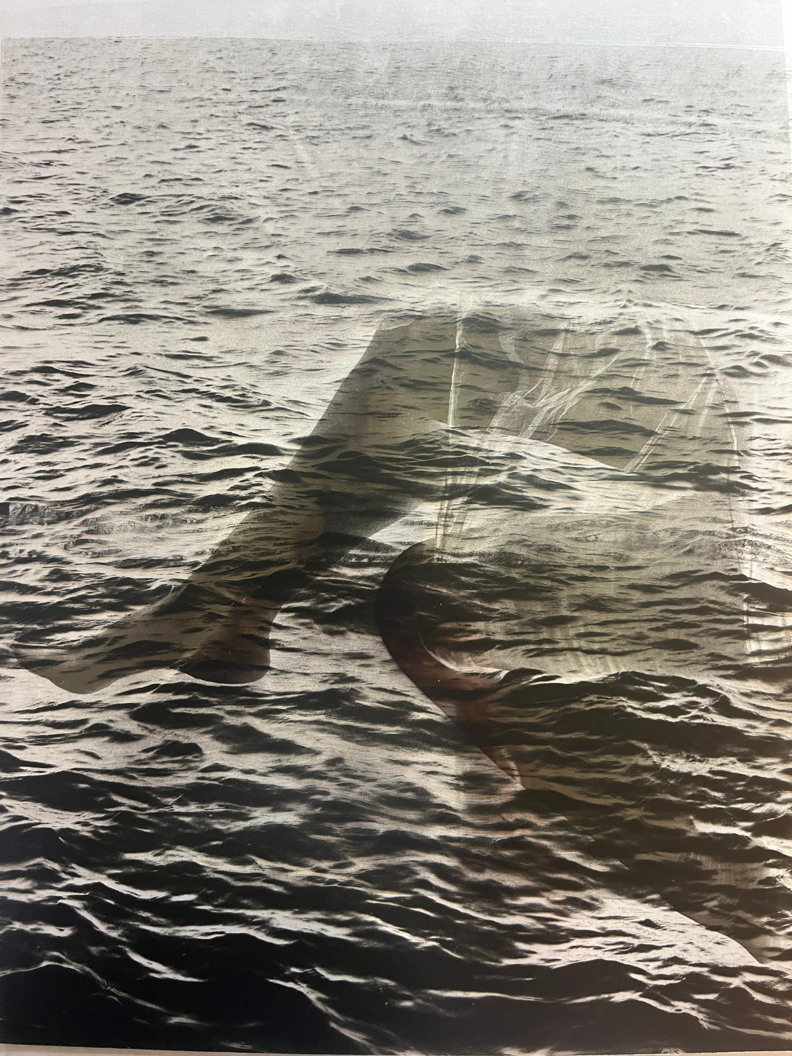 A translucent body form layered over rippling water