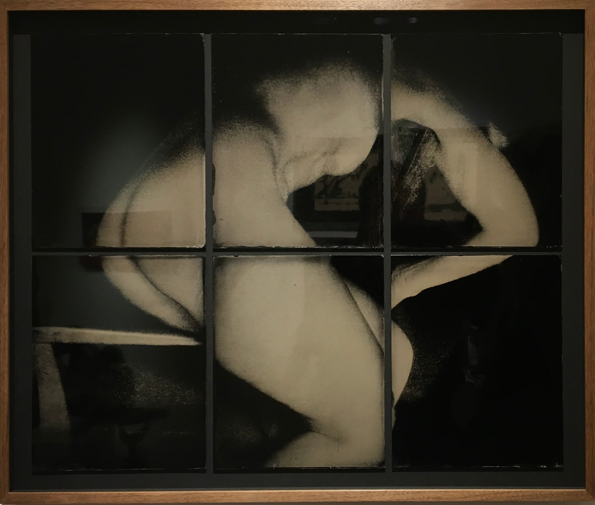 A curled figure spread across a dark grid of rectangular panels
