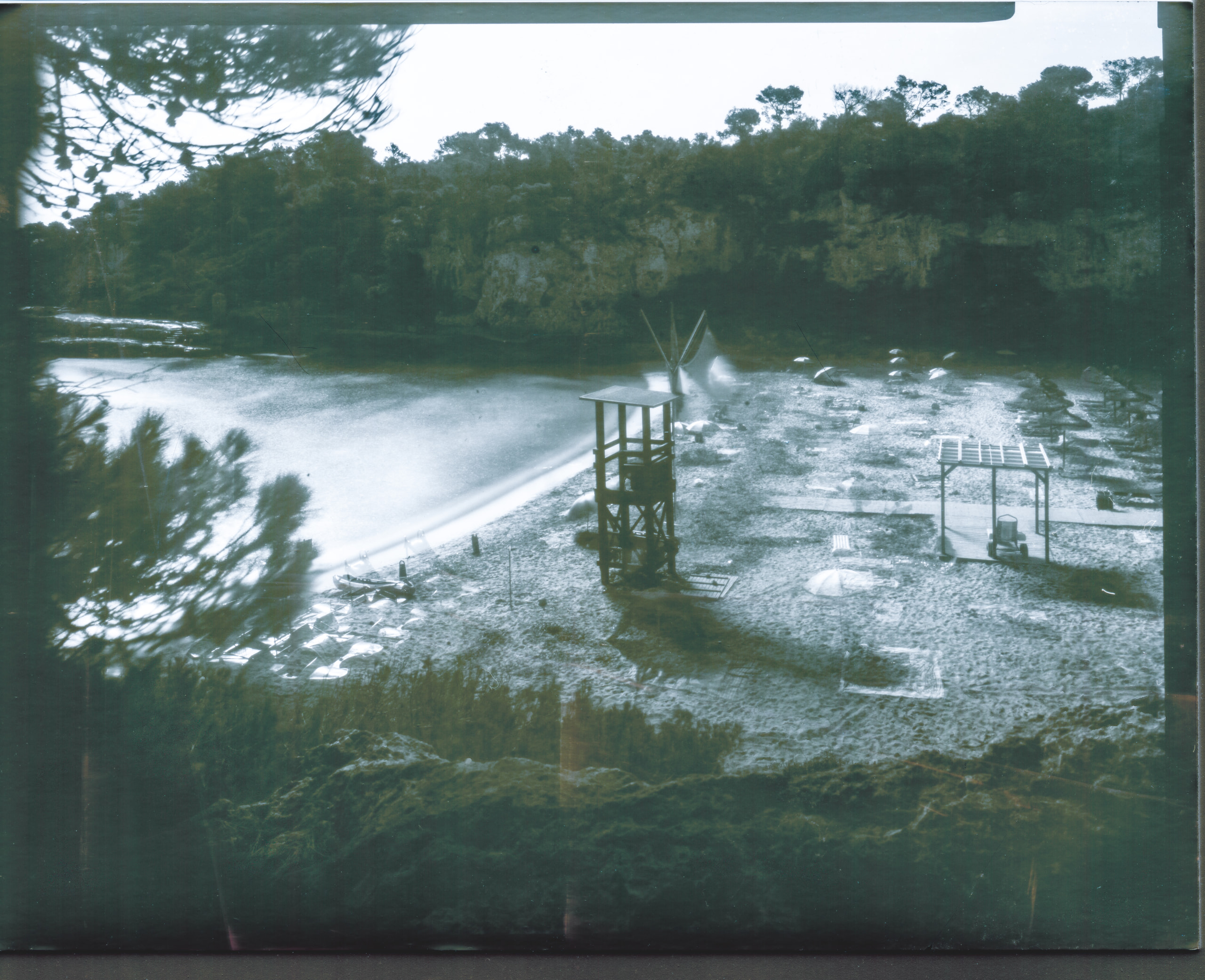 Rocky coastal inlet with wooden platforms beside the water and trees along the shore